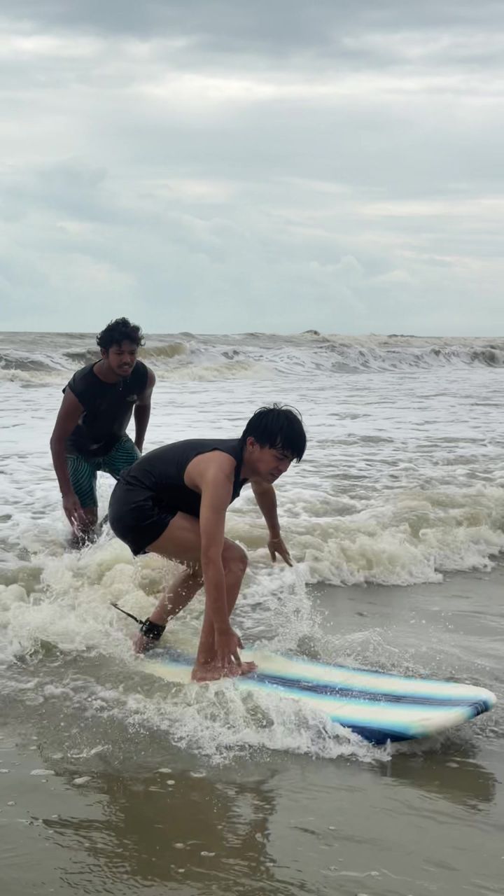 A coach steadying a student on a whitewater wave
